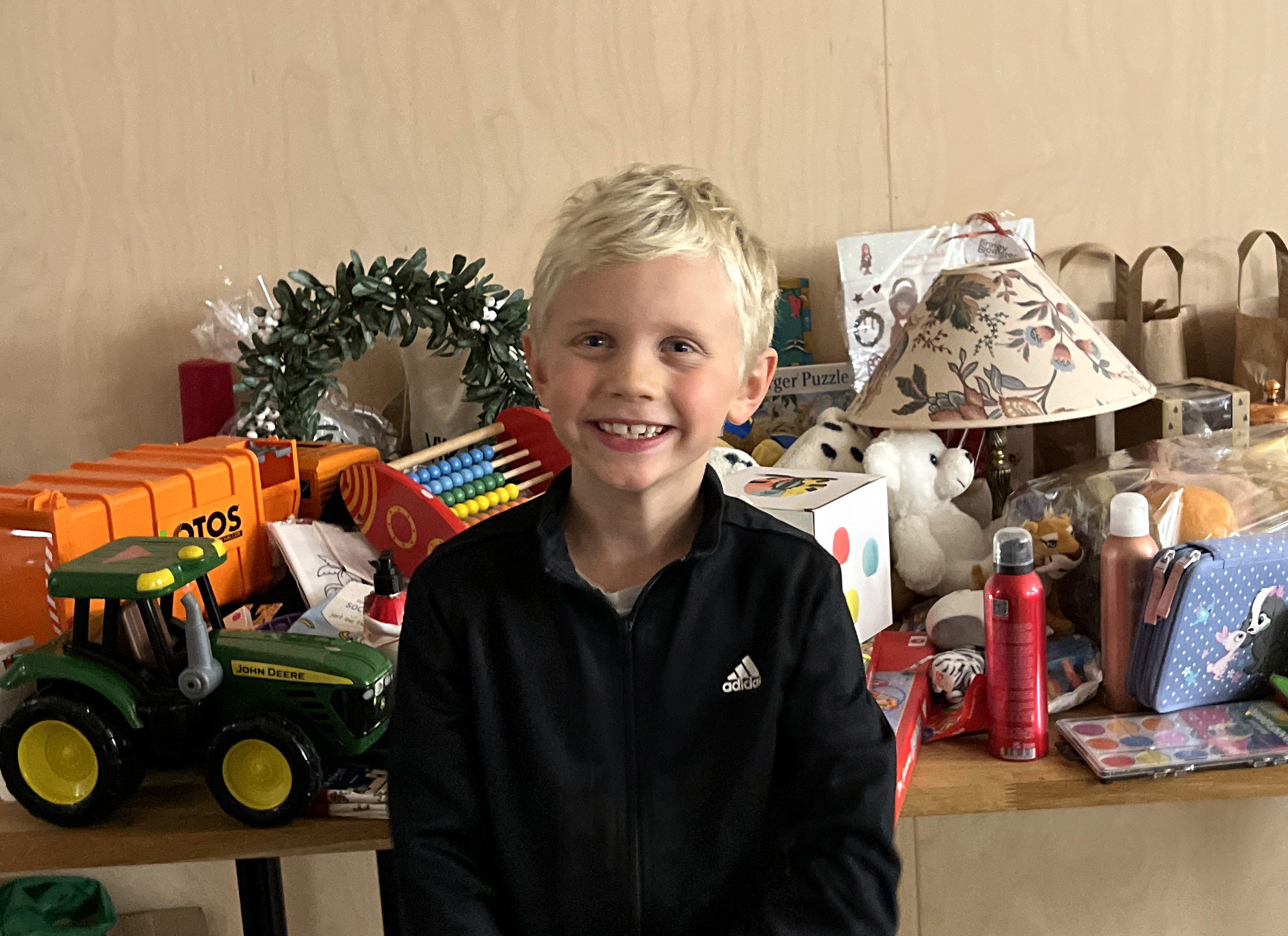 Torjus på seks år foran et salgsbord med varer fra basaren