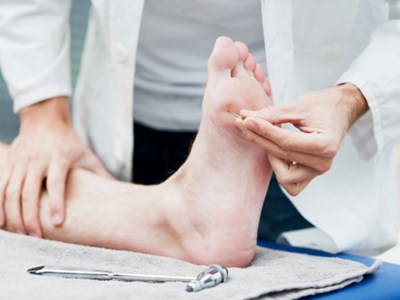 Fotterapaut sjekker foten til en pasient.