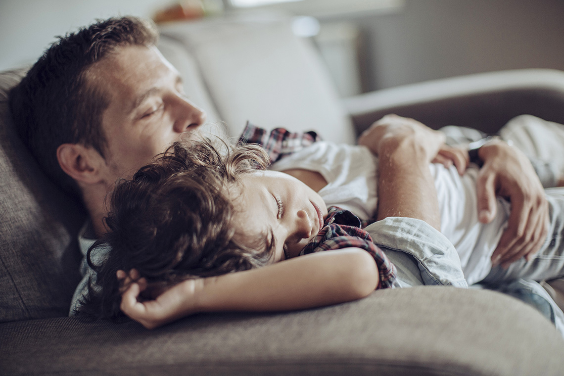 En far som holder et sovende barn